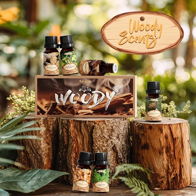 Collection of Woody Scents products on a wooden surface with a blurred green background